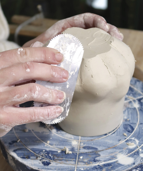 8 Scrape away burrs and scratches with a metal rib to soften the surface of the mug.