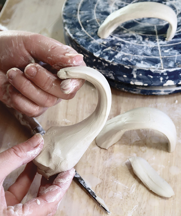 9 Pull a handle from a carrot-shaped piece of clay to the desired handle size for the mug.
