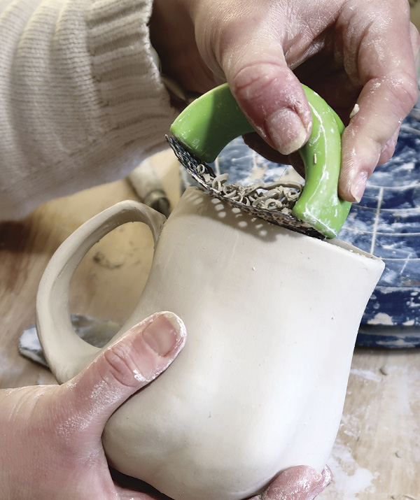 12 Next, use a surform to scrape excess clay along the rim to create a seamless undulation.