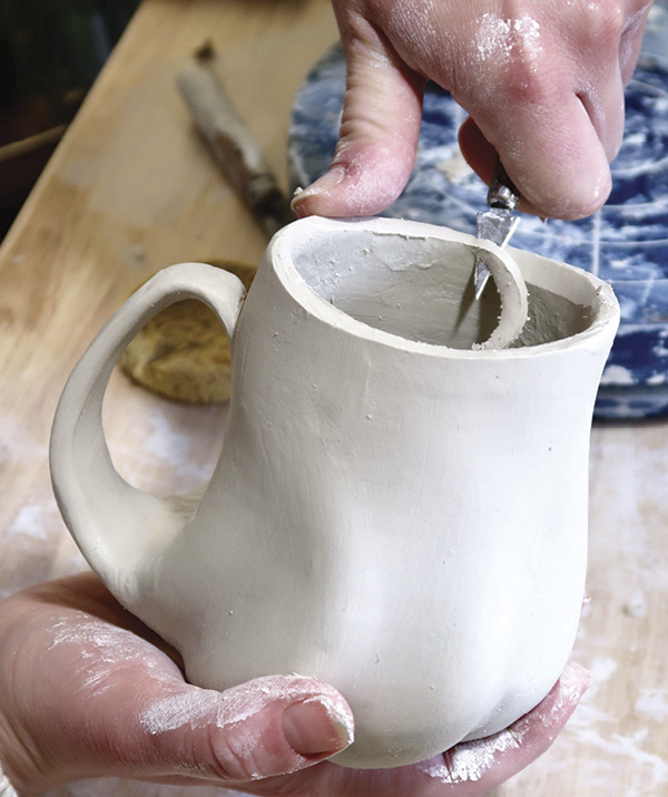 13 To make the lip thin, use a small knife to cut along the inside of the mug’s rim at a 45-degree angle and use a damp sponge to smooth it out.