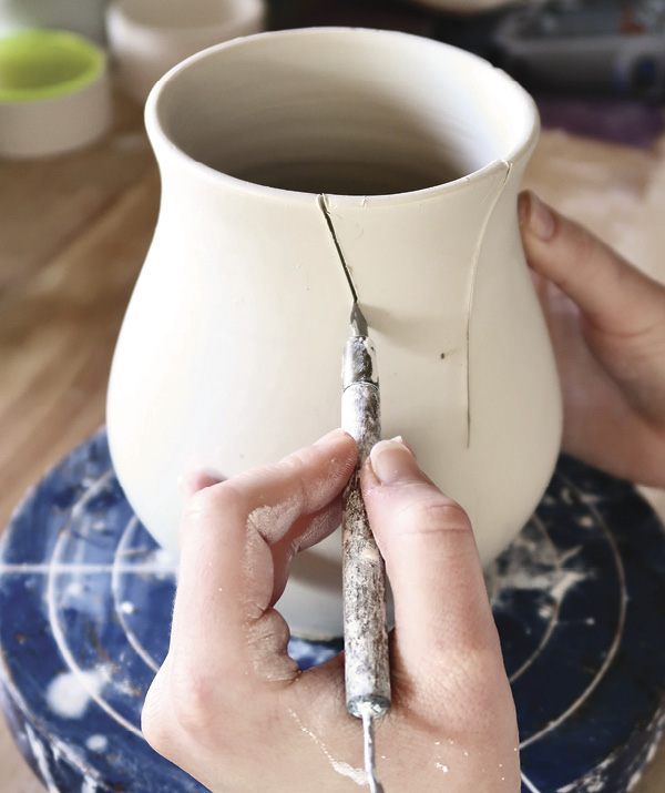 14 Begin by cutting a triangular slice from the wheel-thrown flared vase.