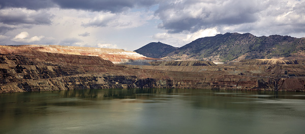 6 View of the Berkeley Pit, a historic copper mining site in Butte, Montana. Today, the Berkeley Pitt is part of one of the largest Superfund areas in the US. Wastewater from thousands of miles of underground mine passageways continually refills the pit with sulfuric acid and arsenic. Photographer: Highsmith, Carol M., The Berkeley Pit, now a heavily acidic wastewater lake, and tourist attraction, in Butte, Montana, a thriving late 1800s and early 1900s gold, silver, and copper mining boomtown, prosperous that it was known as “The Richest Hill on Earth,” 2022, digital photograph. Photo: Library of Congress, Washington, DC, www.loc.gov/pictures/item/2023698362.