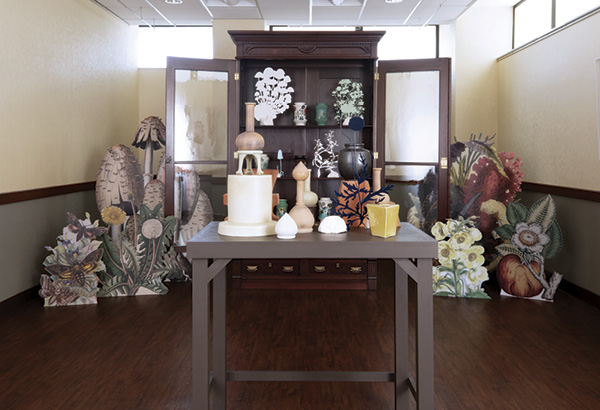 5 Leaves of Plates, 10 ft. (3 m) in width, porcelain, fired to cone 6 in an electric kiln, underglaze-transfer imagery, water-jet-cut and powder-coated aluminum, plastic, wood, Curtis Gates Lloyd’s library cabinet (collection of the Lloyd Library and Museum), 2019. Photo: Jordan Tate.