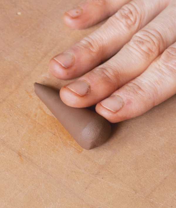 16 Roll a small coil of clay into a truncated cone shape, ensuring the flared top is smooth and crisp.