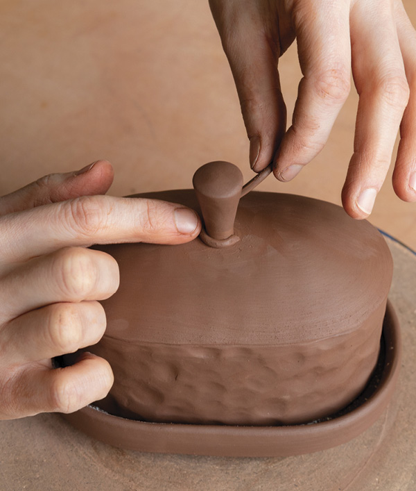 18 Roll out a tiny coil of clay and wrap it around the base of the knob to provide stability and a decorative touch.